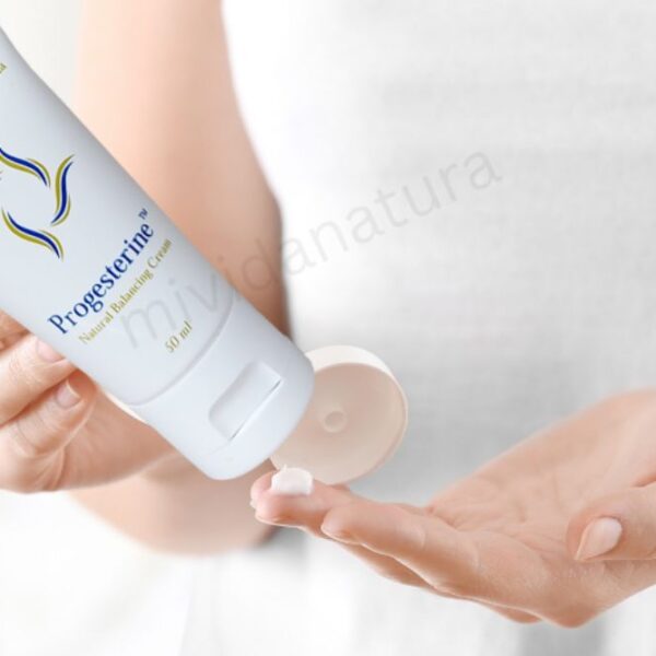 woman with white dress squeezing progestrine cream